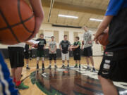 Senior Bryce Mulder (0) joins teammates as they talk things over during practice at Woodland High School on Wednesday afternoon, Feb. 22, 2017.