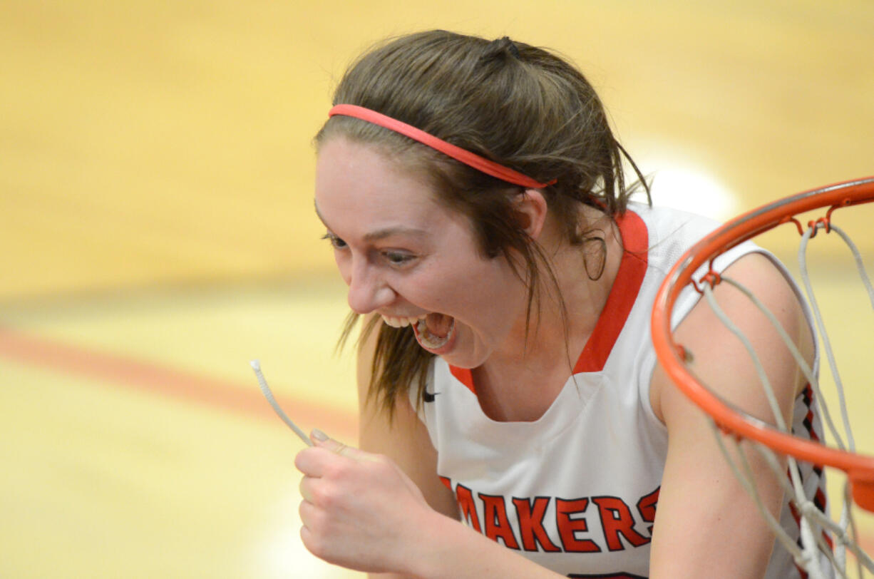 Camas senior Teague Schroeder smiles after cutting a piece of the net after routing Skyview 42-24 to win the 4A Greater St. Helens League title.