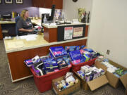 Jenn Clark, administrative assistant in the Clark County council office, works at her desk Friday where boxes of feminine hygiene donations for Share are being stored. A team of volunteers is aiming to collect 3,000 boxes of pads and tampons for Share by Tuesday.