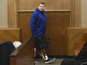 Justin Carey, who was struck by a vehicle while waiting for the school bus in 2013, steps down from the witness stand with his service dog, Shiva, on Wednesday afternoon during the vehicular assault retrial for Shaun Johnson in Clark County Superior Court.