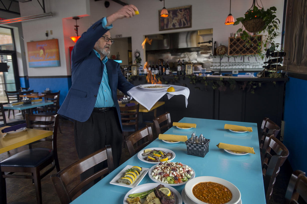 Owner George Vlachos serves up saganaki, which is a Greek cheese dish served flaming, at George&#039;s Molon Lave in Battle Ground on Tuesday morning, Feb. 7, 2017.