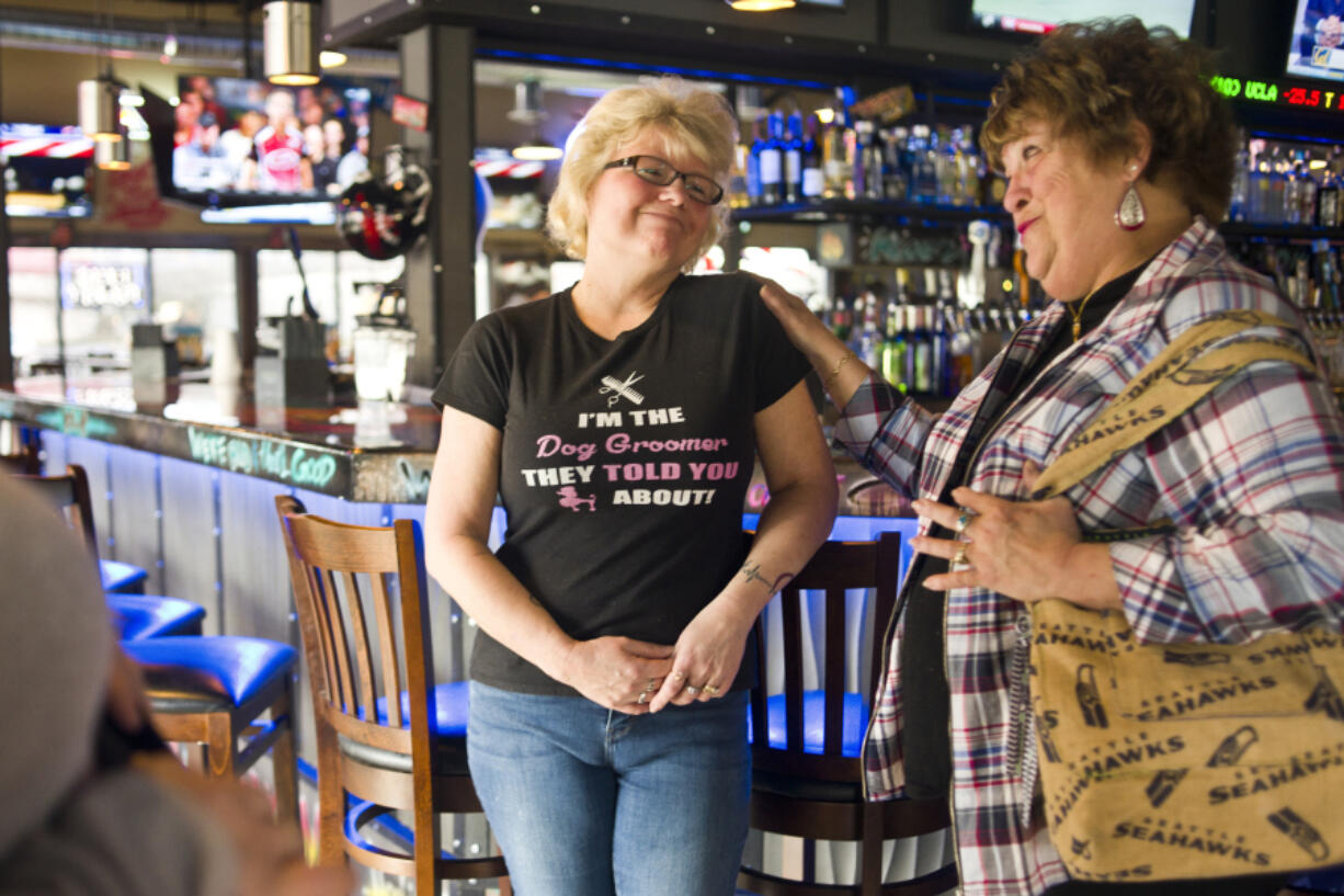 Nancy Koon, right, consoles her sister, Best Friends Dog Grooming owner Sue Picchioni, during a fundraiser Sunday morning at Hooligan&#039;s Sports Bar &amp; Grill in Vancouver. Best Friends lost its shop in the Sifton Market fire in January.