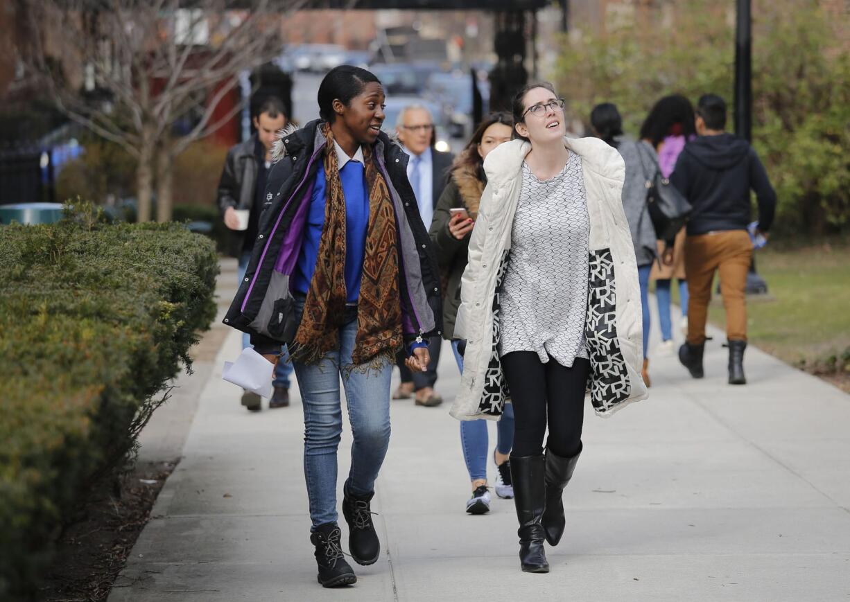 In this Wednesday, Feb. 1, 2017, photo, Brooklyn College student leaders Truth Opaleye, left, and Florencia Salinas walk across campus for class, in New York. Salinas, who despite having her tuition nearly covered in full through scholarships and grants, still expects to graduate with a daunting $50,000 in debt.