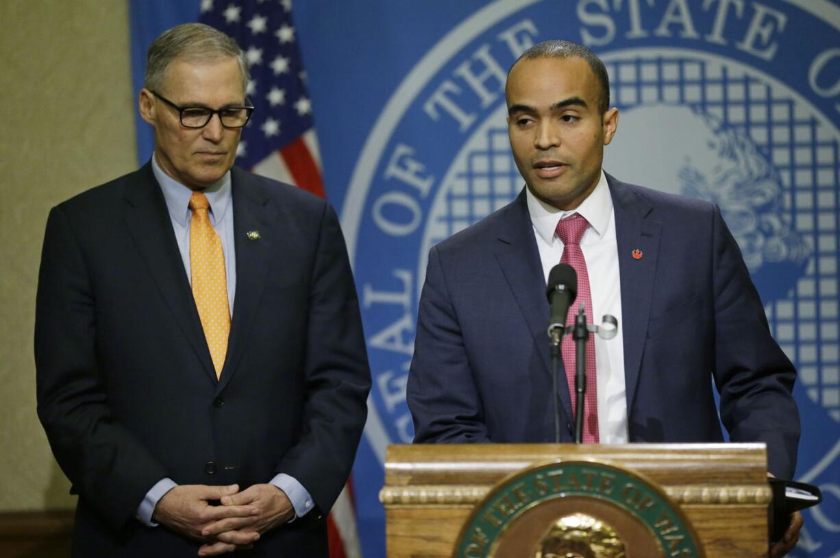 Washington Gov. Jay Inslee, left, listens as his general counsel, Nick Brown, right, takes questions from reporters, Thursday, Feb. 23, 2017, at the Capitol in Olympia, Wash., after Inslee signed an executive order to ensure that state workers don't help carry out President Donald Trump's immigration policies. Trump has said he wants to expand the number of deportations of people in the country illegally, and Inslee said Thursday that his order reaffirms the state's commitment to tolerance and ensures that state workers roles are to provide services for residents and not to enforce immigration statutes. (AP Photo/Ted S.