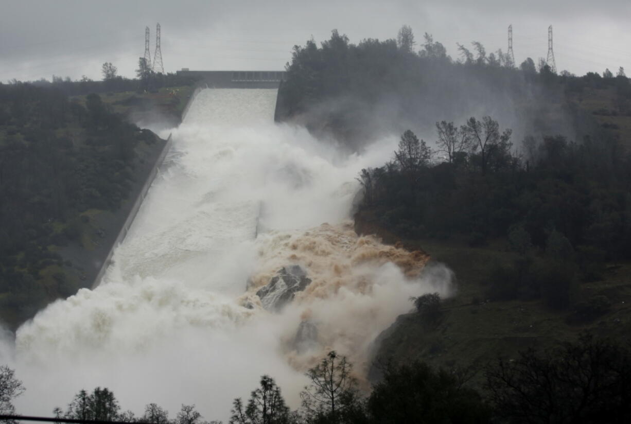 Water flows through break in the wall of the Oroville Dam spillway Thursday in Oroville, Calif. The torrent chewed up trees and soil alongside the concrete spillway before rejoining the main channel below. Engineers don&#039;t know what caused what state Department of Water Resources spokesman Eric See called a &quot;massive&quot; cave-in that is expected to keep growing until it reaches bedrock.