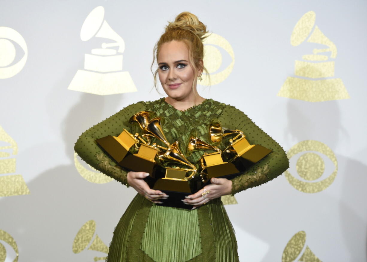 Adele poses in the press room with the awards for album of the year for &quot;25&quot;, song of the year for &quot;Hello&quot;, record of the year for &quot;Hello&quot;, best pop solo performance for &quot;Hello&quot;, and best pop vocal album for &quot;25&quot; at the 59th annual Grammy Awards at the Staples Center on Sunday, Feb. 12, 2017, in Los Angeles.