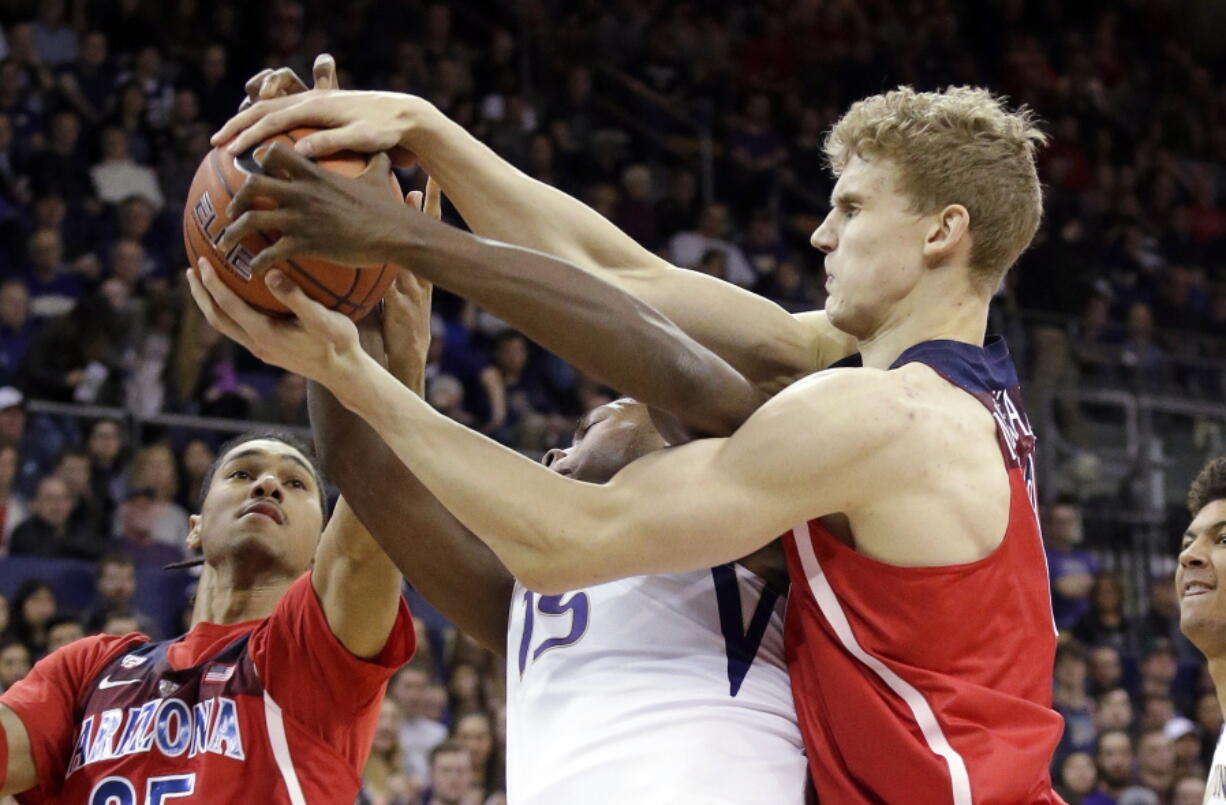 Washington&#039;s Noah Dickerson, center, battles Arizona&#039;s Keanu Pinder, left, and Lauri Markkanen for a loose ball during the first half of an NCAA college basketball game Saturday, Feb. 18, 2017, in Seattle.