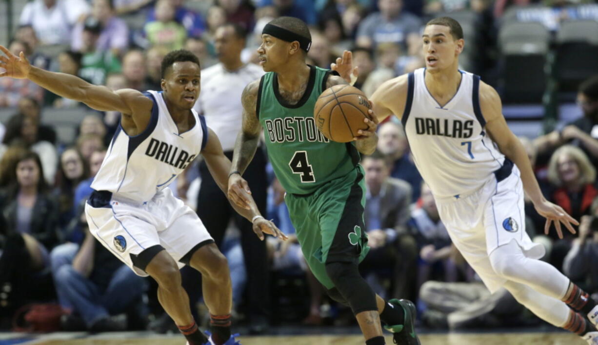 Boston Celtics guard Isaiah Thomas (4) dribbles against Dallas Mavericks defenders Yogi Ferrell (11) and Dwight Powell during the first half of an NBA basketball game in Dallas, Monday, Feb. 13, 2017.