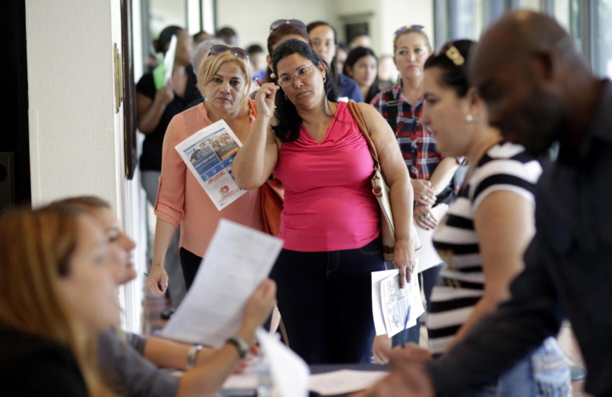 Reina Borges, left, stands in line July 19, 2016, to apply for a job with Aldi at a job fair in Miami Lakes, Fla. U.S. employers stepped up hiring last month, adding a healthy 227,000 jobs, and more Americans began looking for work, a sign that President Donald Trump has inherited a robust job market.