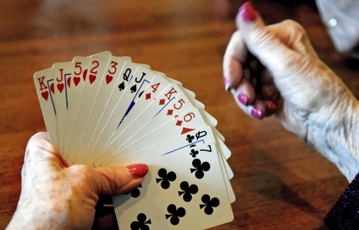 A card player studies her hand during a bridge game at a restaurant in St. Paul, Minn. Research published on Jan. 30 shows that even in one&#039;s 70s and beyond, simple activities including web-surfing, playing bridge and socializing can stave off mental decline.