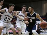 Gonzaga&#039;s Nigel Williams-Goss, right, drives the ball against Saint Mary&#039;s Dane Pineau (22) and Joe Rahon, center, during the first half of an NCAA college basketball game Saturday, Feb. 11, 2017, in Moraga, Calif.