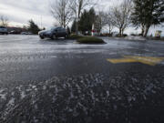 A layer of ice covers the Fisher&#039;s Landing Fred Meyer parking lot on Friday morning. Rain -- the non-freezing, liquid kind -- is forecast for this weekend.