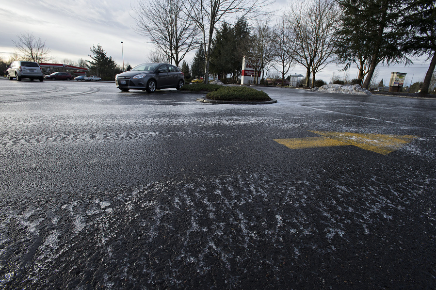 A layer of ice covers the Fisher&#039;s Landing Fred Meyer parking lot on Friday morning. Rain -- the non-freezing, liquid kind -- is forecast for this weekend.