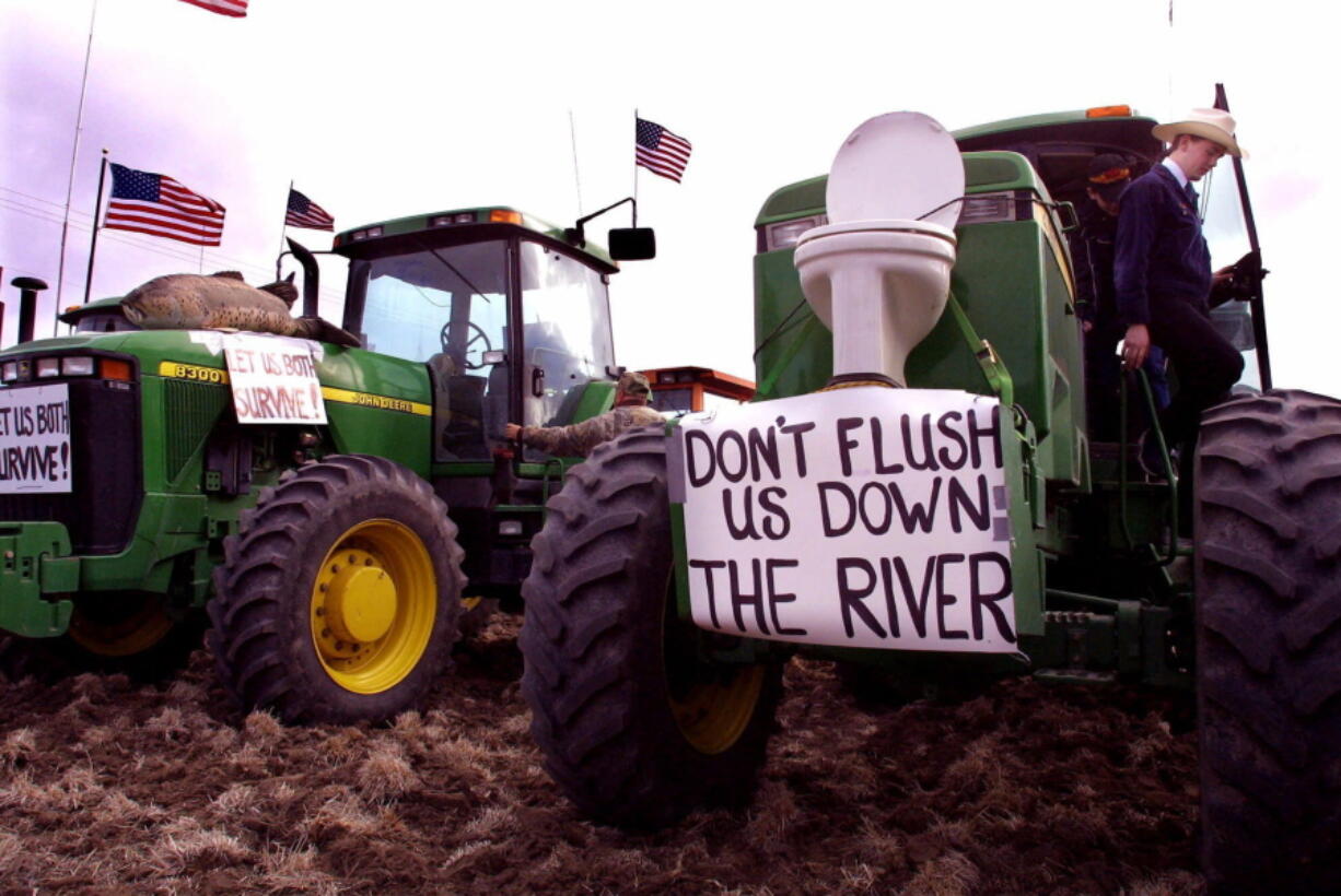 FILE - In this March 9, 2001, file photo, farmers from the Klamath Basin use farm equipment during a water rights protest at the Bureau of Reclamation in Klamath Falls, Ore. A federal trial involving water rights in the Klamath Basin has adjourned, bringing an end to the trial. During the two-week trial in Washington, D.C., more than 20 irrigators testified of their losses in 2001 when water was shut off to benefit endangered fish downstream. Attorneys in the case say it will take a significant amount of time to process all the records in the case. Closing oral arguments are tentatively planned for May 9.