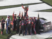 Kurt Busch, top, celebrates with crew members after winning the NASCAR Daytona 500 auto race at Daytona International Speedway in Daytona Beach, Fla., Sunday, Feb. 26, 2017.