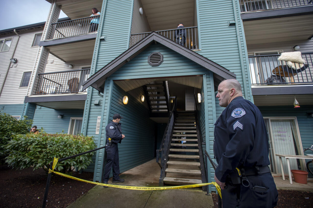 Sgt. Pat Moore, right, works with fellow police officers at the scene of an officer-involved shooting as a resident looks on, upper left, at Springfield Meadows on Friday morning, Feb. 10, 2017.