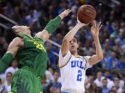 UCLA guard Lonzo Ball, right, shoots as Oregon forward Dillon Brooks defends during the second half of an NCAA college basketball game, Thursday, Feb. 9, 2017, in Los Angeles. UCLA won 82-79. (AP Photo/Mark J.