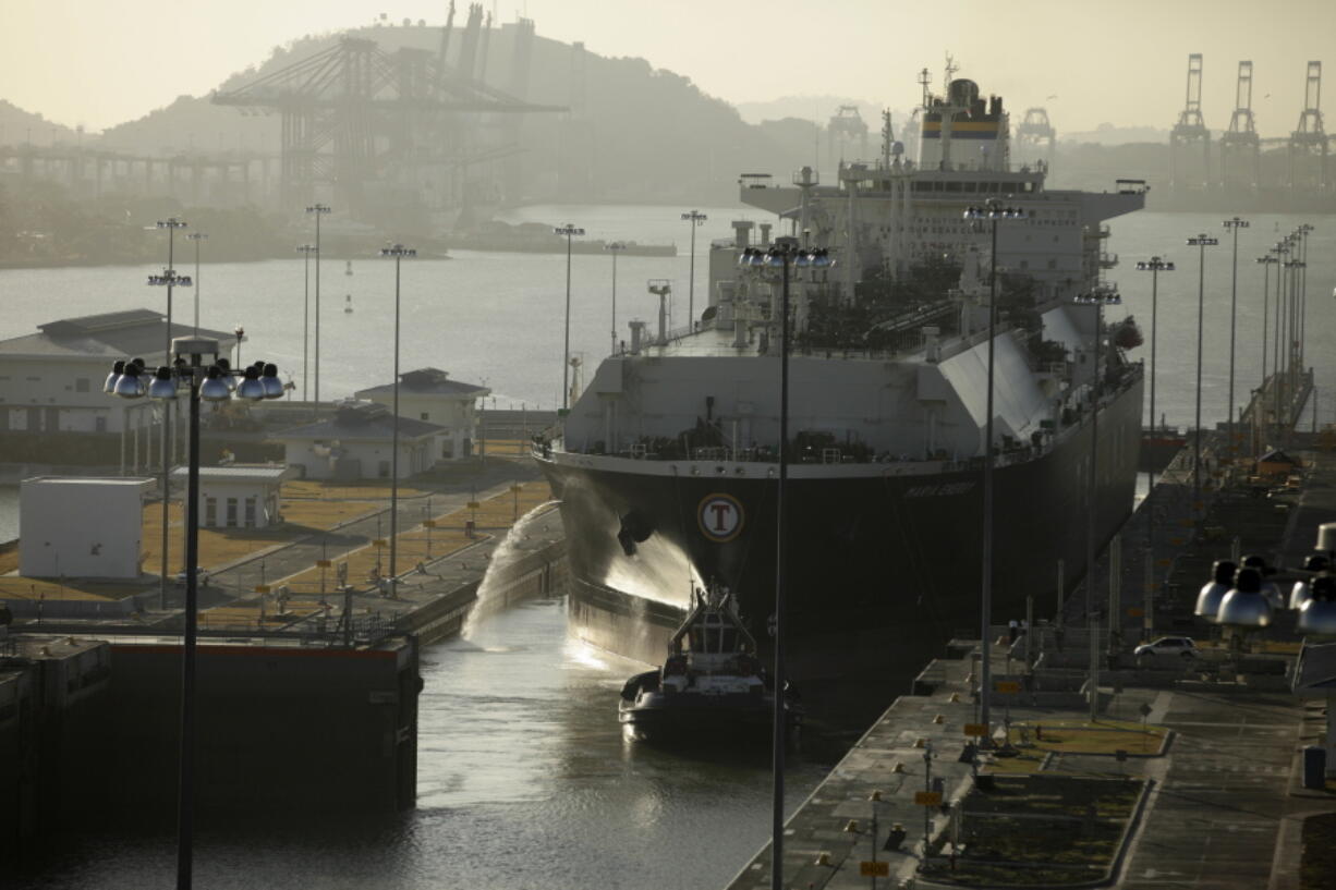 In this Jan. 19, 2017 photo, a liquefied natural gas tank ship is guided through the Cocoli locks, part of the new Panama Canal expansion project in Cocoli, Panama. Pilots on the bridge of cargo ships and tug operators sometimes deliberately nudge gently up against the canal&#039;s barriers simply as a way to properly align the vessels. That has lessened somewhat, but the battered bumpers are evidence that not all passages are smooth.