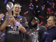 New England Patriots' Tom Brady holds the Vince Lombardi Trophy after defeating the Atlanta Falcons in overtime at the NFL Super Bowl 51 football game Sunday, Feb. 5, 2017, in Houston. The Patriots defeated the Falcons 34-28. At right is Patriots head coach Bill Belichick.