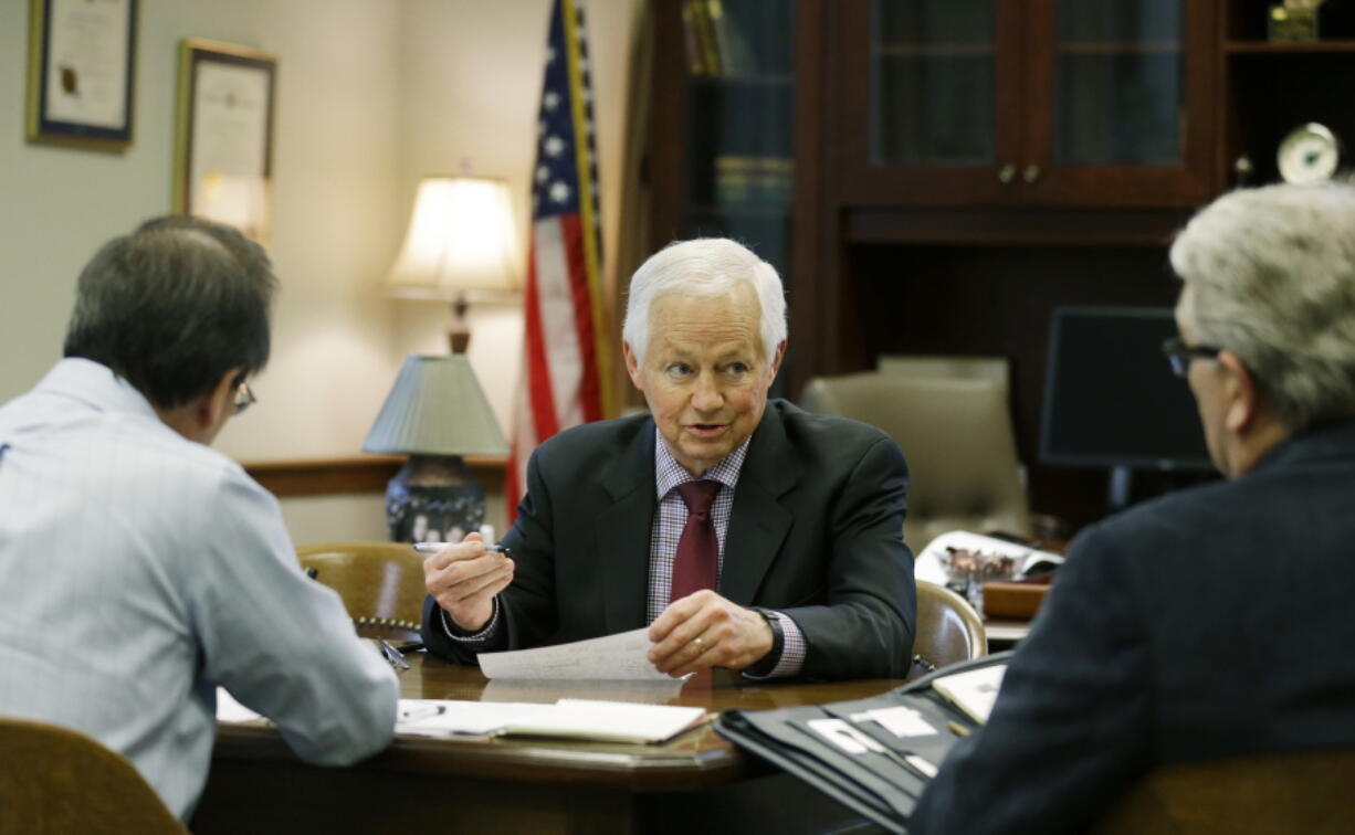 Washington Insurance Commissioner Mike Kreidler, center, conducts a meeting in his office in 2017 at the Capitol in Olympia. (Ted S.