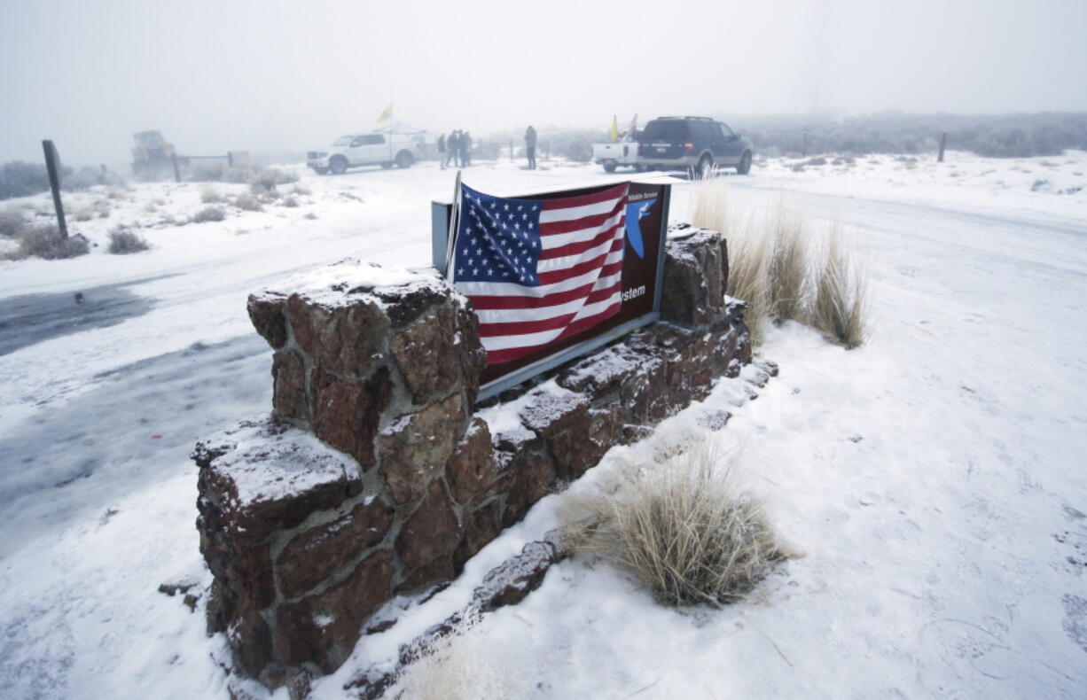 An American flag hangs on the sign at the front entrance of the Malheur National Wildlife Refuge near Burns, Ore.