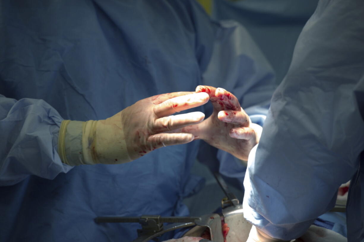 FILE - In this Tuesday, June 28, 2016 file photo, surgeons discuss a procedure during a surgery in Washington. In a study released Wednesday, Feb. 15, 2017, complications including infections and surgical incision problems were most common in patients whose surgeons had received lots of earlier complaints about their behavior.