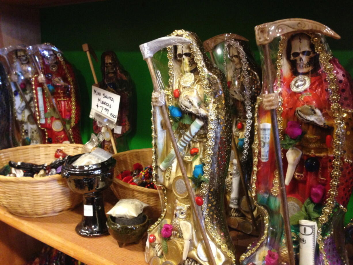 Statues of La Santa Muerte are displayed at the Masks y Mas art store in Albuquerque, N.M.