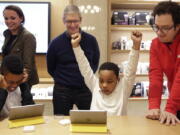 Jaysean Erby raises his hands Dec. 9, 2015, as he solves a coding problem while Apple CEO Tim Cook watches from behind at an Apple Store in New York as Apple hosted Hour of Code events around the world.