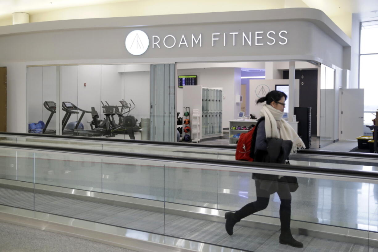 In this Jan. 30, 2017 photo, a traveler walks past the soon-to-be-open ROAM Fitness gym at Baltimore-Washington International Thurgood Marshall Airport in Linthicum, Md. Working out while waiting for your flight will soon be an option at BWI, where the only gym at a U.S. airport past security will open this week, with plans for 20 more at airports by 2020.