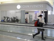 In this Jan. 30, 2017 photo, a traveler walks past the soon-to-be-open ROAM Fitness gym at Baltimore-Washington International Thurgood Marshall Airport in Linthicum, Md. Working out while waiting for your flight will soon be an option at BWI, where the only gym at a U.S. airport past security will open this week, with plans for 20 more at airports by 2020.