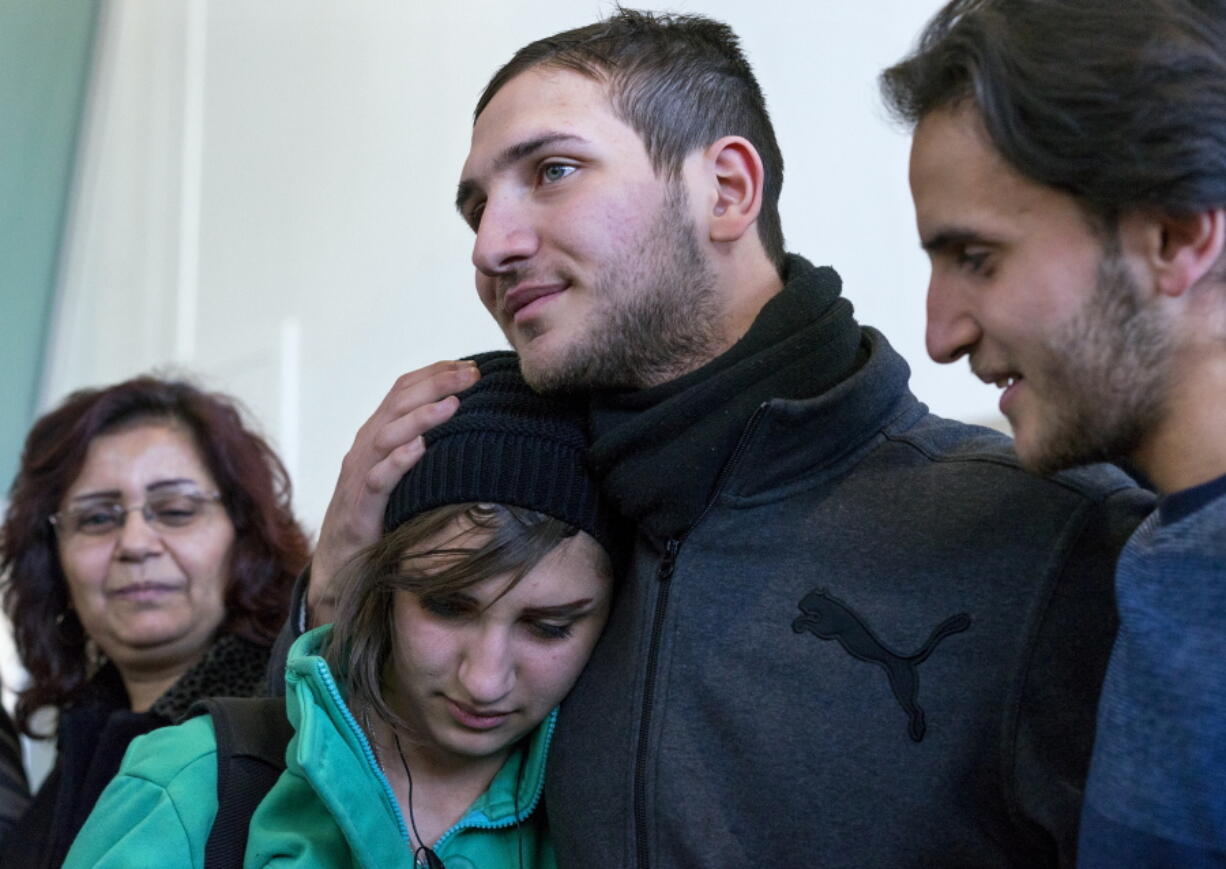 Tawfik Assali, 21, center, of Allentown, Pa., embraces his sister Sarah Assali, 19, upon her and other family members&#039; arrival from Syria at John F. Kennedy International Airport in New York on Monday. Right is Mathew Assali, 17, who arrived today. Attorneys said Dr. Assali&#039;s brothers, their wives and their two teenage children returned to Syria after they were denied entrance to the United States on Jan. 28 although they had visas in hand after a 13-year effort.