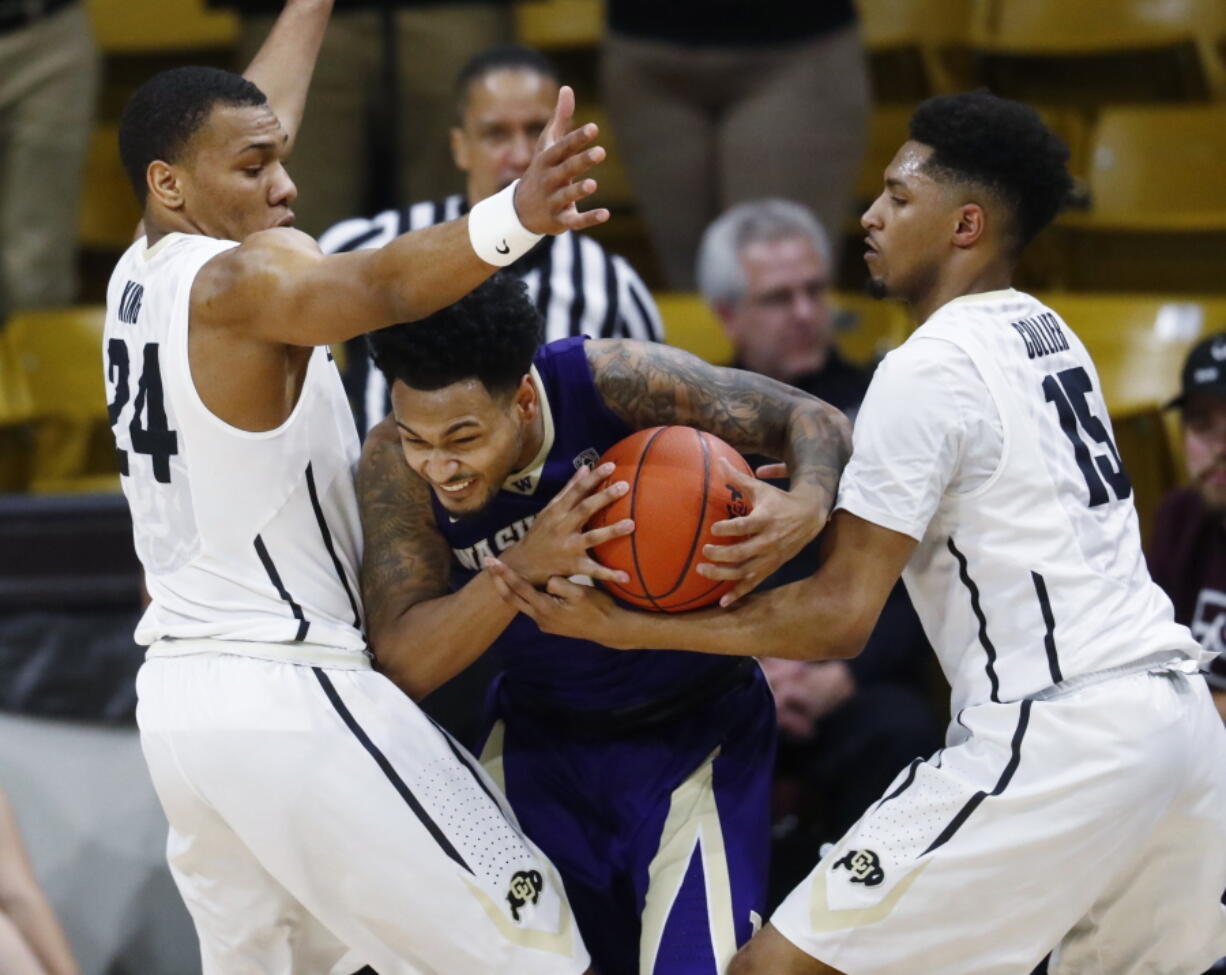 Washington guard David Crisp, center, gets trapped in the corner with the ball by Colorado guards George King, left, and Dominique Collier in the first half of an NCAA college basketball game Thursday, Feb. 9, 2017, in Boulder, Colo.