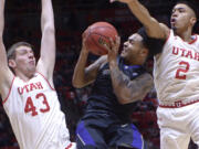 Utah forward Jakub Jokl (43) and guard Sedrick Barefield (2) stop Washington guard David Crisp (1) during an NCAA college basketball game Saturday, Feb. 11, 2017, in Salt Lake City.