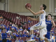 La Center guard, Hunter Ecklund (23), drives past La Salle's Jeffrey Vargas (3) for a lay-in during the first round of the WIAA 1A boys state tournament on Wednesday, Mar. 1, 2017, at the Yakima Valley SunDome.  The La Center Wildcats defeated La Salle Lightning 61-51.