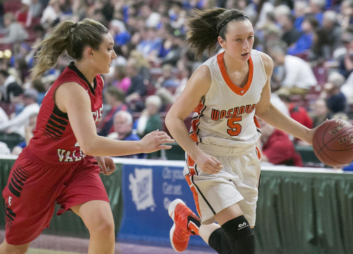 Washougal's Beyonce Bea (5), drives around East Valley's 
 Sydnee Hooker (12), during the first round of the WIAA 2A girls state tournament on Wednesday, Mar. 1, 2017, at the Yakima Valley SunDome. The Washougal Panthers defeated East Valley (Yakima) Red Devils 52-36. (TJ Mullinax/for The Columbian)