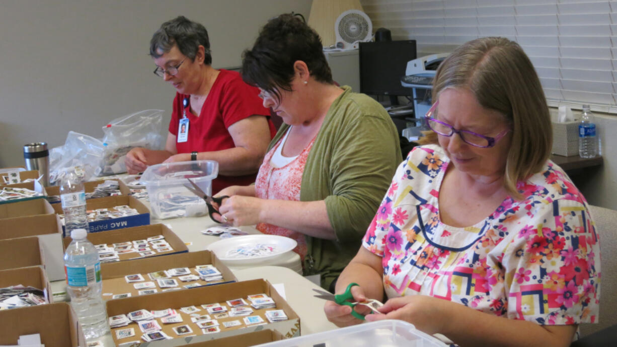 Dianne Archer, 71, of Poughkeepsie, N.Y., left, Michele Whitlock, 50, of Big Fork, Mont., center, and Char Isham, 60, of Mattawan, Mich., volunteer in the postage-stamp ministry at Wycliffe Associates in southeast Orange County, Fla.