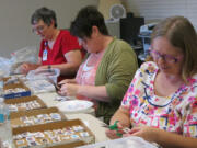 Dianne Archer, 71, of Poughkeepsie, N.Y., left, Michele Whitlock, 50, of Big Fork, Mont., center, and Char Isham, 60, of Mattawan, Mich., volunteer in the postage-stamp ministry at Wycliffe Associates in southeast Orange County, Fla.