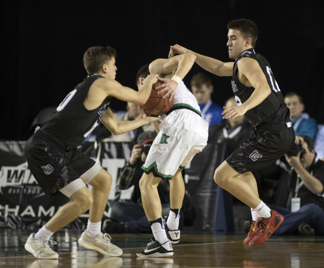 Union's Zach Reznick, left, attempts to steal the ball from Kentwood's Koby Huerta as his teammate, Tyler Combs, right, keeps Huerta from getting to the basket.