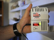 Retired professor John Koroloff holds a radon detector in his basement  in 2012 in Vancouver.