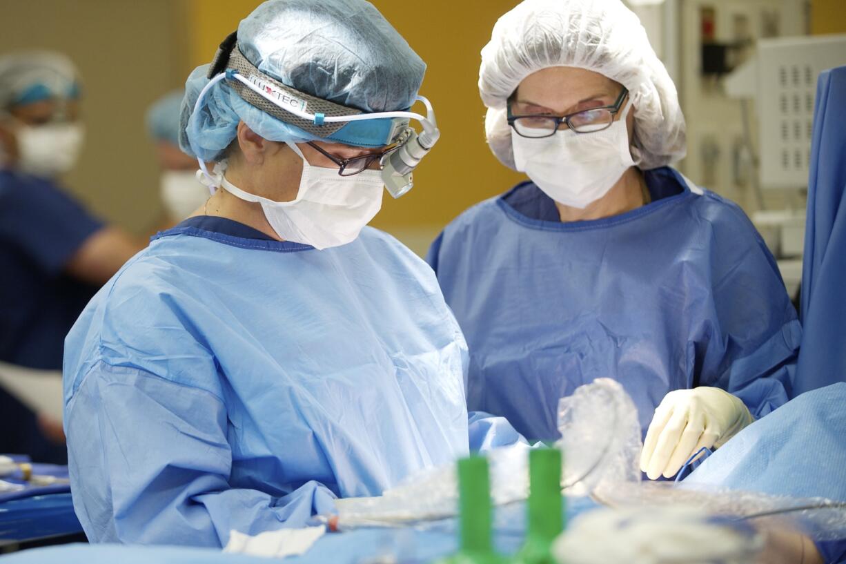 Dr. Storm Dickerson performs a bilateral nipple-sparing mastectomy in 2013 at PeaceHealth Medical Center in Vancouver. At right is Julie Blomdahl, RNFA.