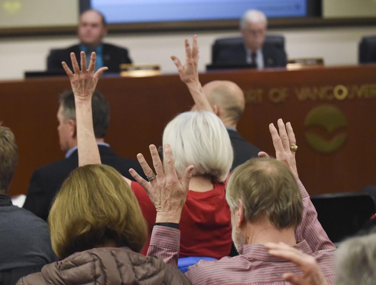 Community members in opposition to the proposed Vancouver oil terminal wave their fingers in support of commentary delivered at a board meeting of the Port of Vancouver Board of Commissioners on Tuesday.