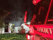 A firefighter extinguishes a blaze early Friday morning in Vancouver's Hough neighborhood. The fire damaged one half of a duplex on West 24th Street. No injuries were reported.