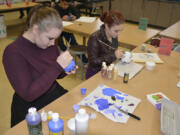 Washougal: Through a Washougal Schools Foundation mini grant, advanced arts students, such as Haleigh Metz, left, and Tianna Godin, made Zulu Coconuts by painting coconut shells that came in from Florida.