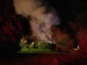 Smoke pours from an old farmhouse near Ridgefield on Monday evening.