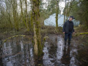 Larry Johns wades through the water that&#039;s built up on his property during the rainy season that he worries will ruin his property.