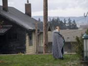 Vancouver resident Amanda Shelton takes a call after firefighters extinguished a fire at her parents' house on West 36th Street on Tuesday afternoon, March 28, 2017.