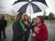 Lindsey Smith, 13, right, is joined by her mom, Carrie Smith, left, her aunt, Leslie Goodnight, and family friend, Jasmine Freeman, as they look over injuries they say she sustained after a fellow student punched her in the face Wednesday, as seen outside McLoughlin Middle School on Friday afternoon, March 17, 2017. School district officials announced Vancouver police are investigating the allegations.