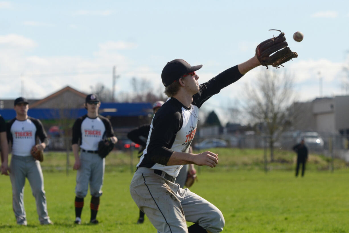 Battle Ground senior Isaiah Smith catches a fly ball during baseball practice at Battle Ground High School on Tuesday, March 21, 2017.