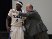 Clark College basketball interim head coach Kevin Johnson gives instructions to Surmon Neal.