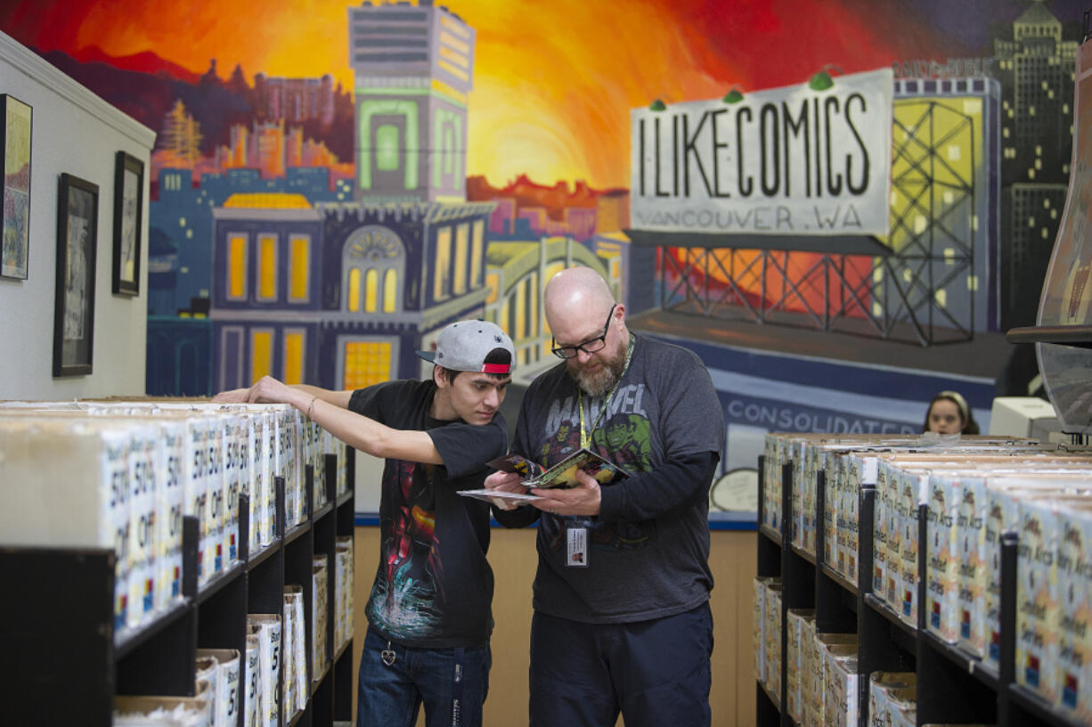 Gateway to Adult Transition Education program member Brayden Oh, left, works with special education teacher Mark Shellenberger as they organize comics at I Like Comics on Thursday morning. The program helps students with developmental disabilities gain job skills and connect with social services.